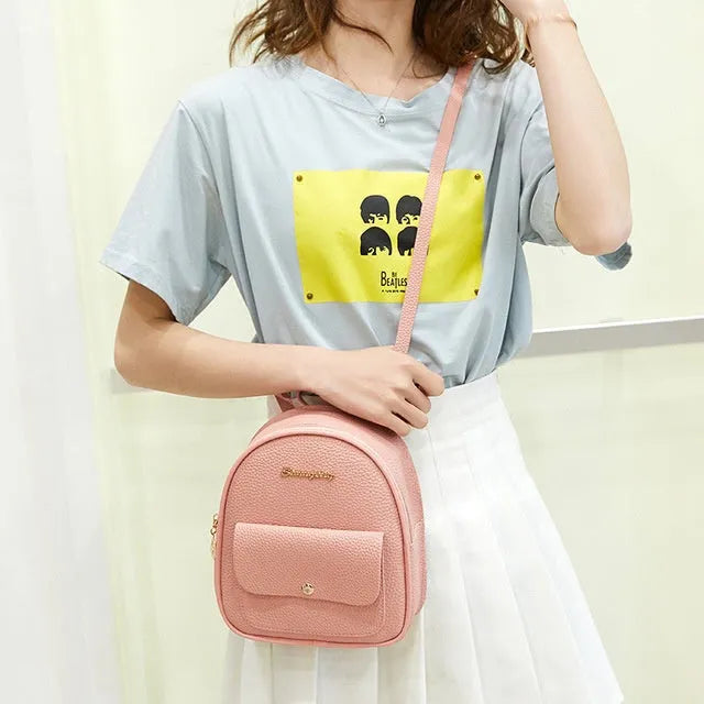 Women's black PU backpack purse with letter design and shoulder strap showing compact 18.5cm length
