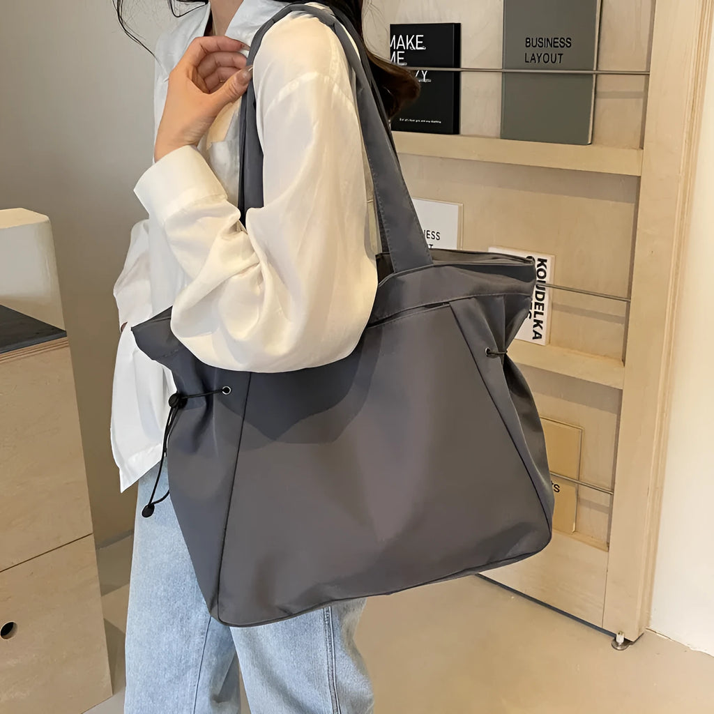 Soft Oxford cloth commuter tote bag in a street style, shown in a folded position.
