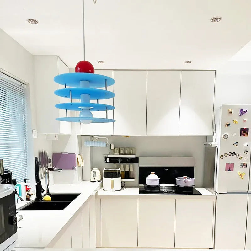 Modern macaron-shaped PH5 chandelier with a frosted shade, shown in a restaurant setting.