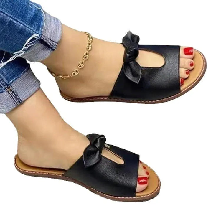 Ladies casual sandals with a bow detail and fish mouth slipper style in black, pink, or gold.