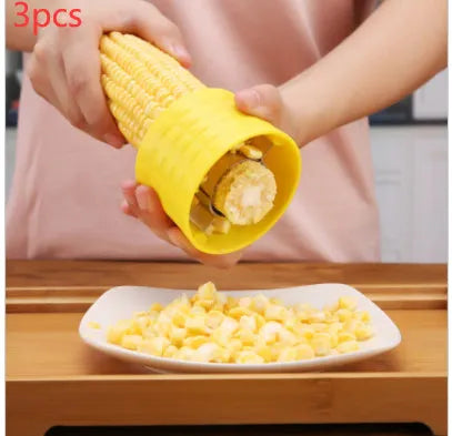 Yellow manual corn grinder thresher with corn-shaped design and stainless steel peeling gear.