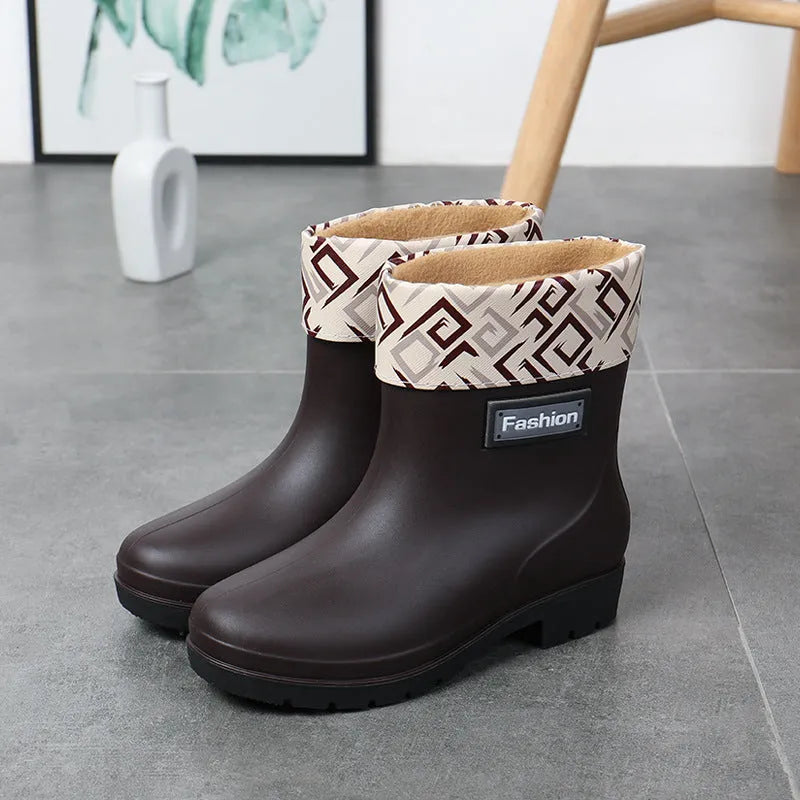 Women's mid-calf PVC rain boot in black with a low heel on a white background.