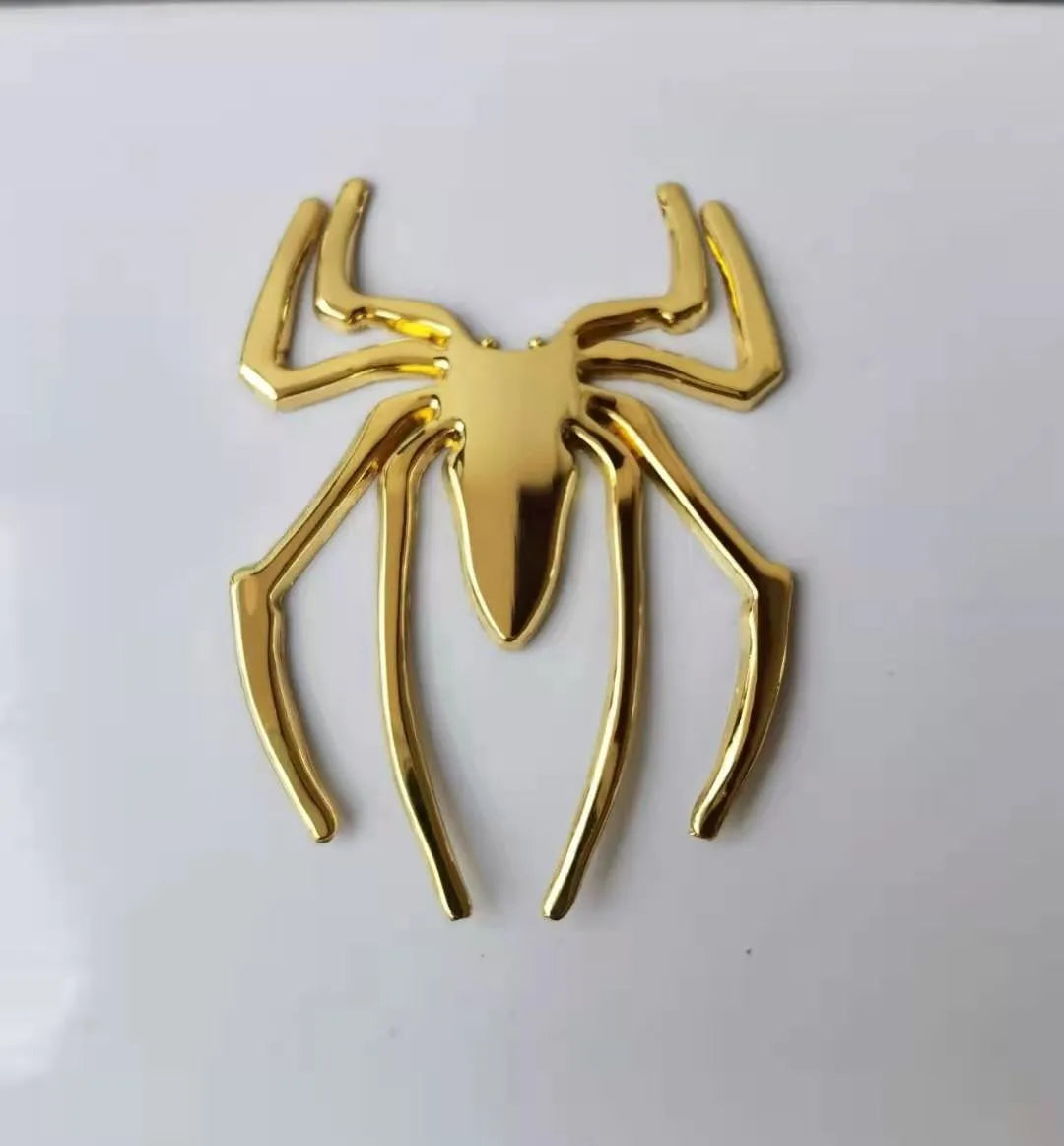 Three-dimensional metal spider bumper sticker in zinc alloy, shown in gold colour.