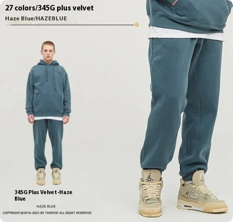 Man wearing dark brown velvet sweatpants with an ankle band and elastic waist.