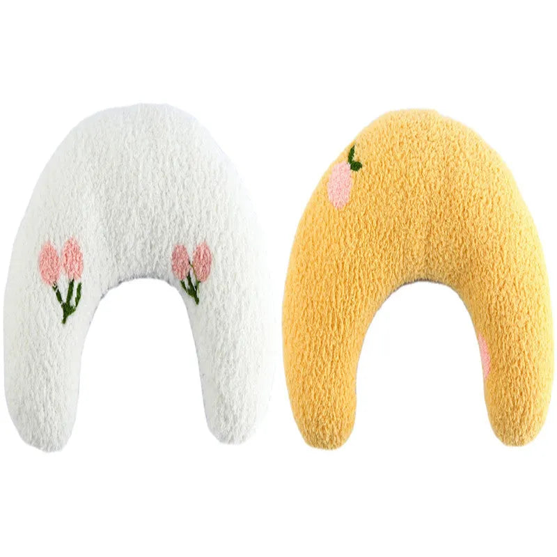 Small white U-shaped plush pet pillow for cats and small dogs on a neutral background.