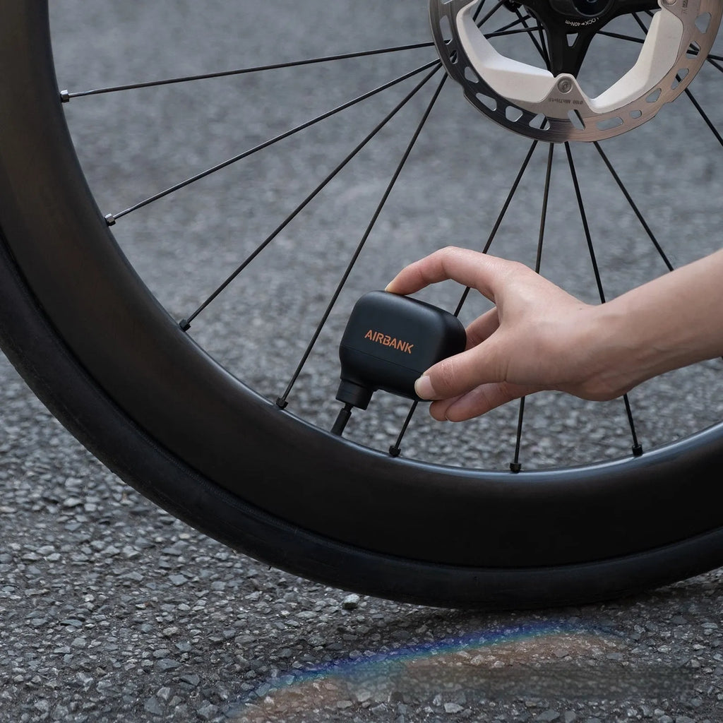 Black plastic electric bike pump with USB charging port and waterproof storage bag