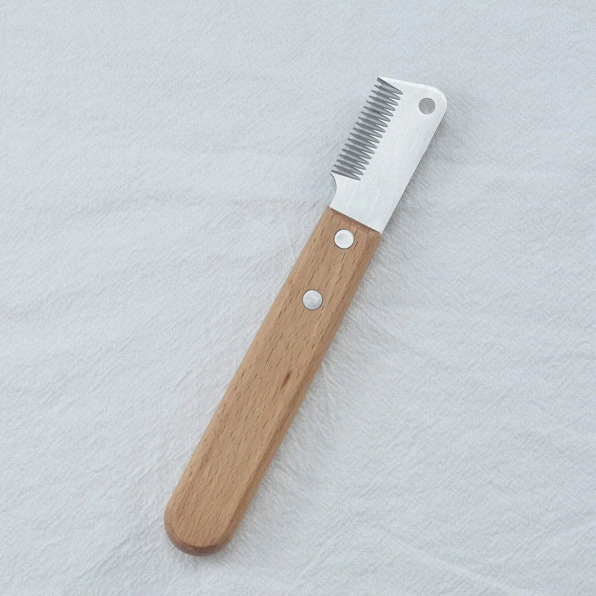 Pet stripping comb with wood handle and metal teeth for grooming long-haired dogs and cats.