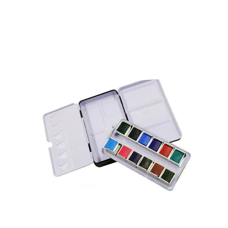 Square tinplate three-fold paint box for solid watercolours, shown open with empty slots.