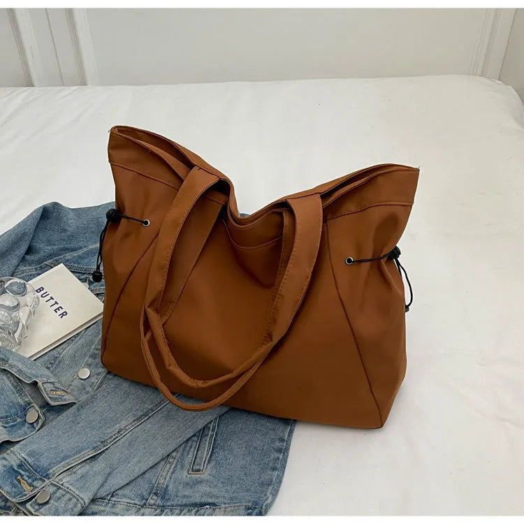 Soft Oxford cloth commuter tote bag in a street style, shown in a folded position.