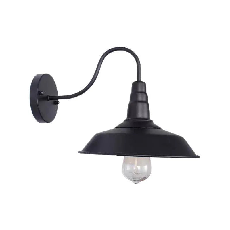 Retro style metal wall lamp in copper finish mounted on a stone wall.