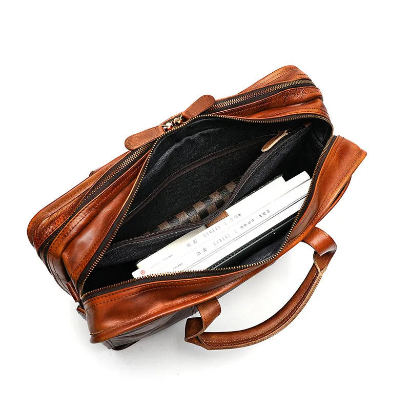 Vintage brown leather men's briefcase open showing internal laptop pocket and document organisers