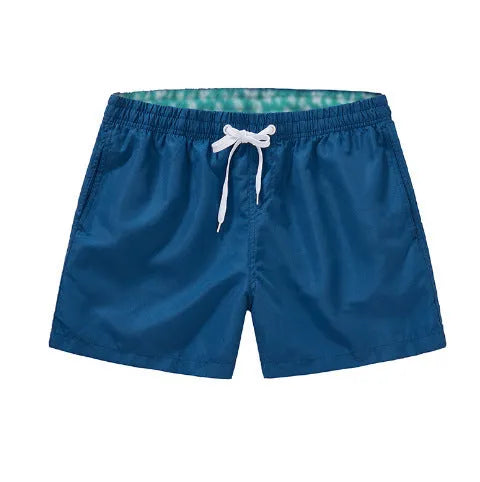 Men's straight-leg beach shorts in polyester fabric shown in a solid colour, laid flat.