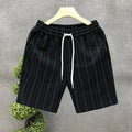Man's black and white striped casual shorts with elastic waistband on a plain background.