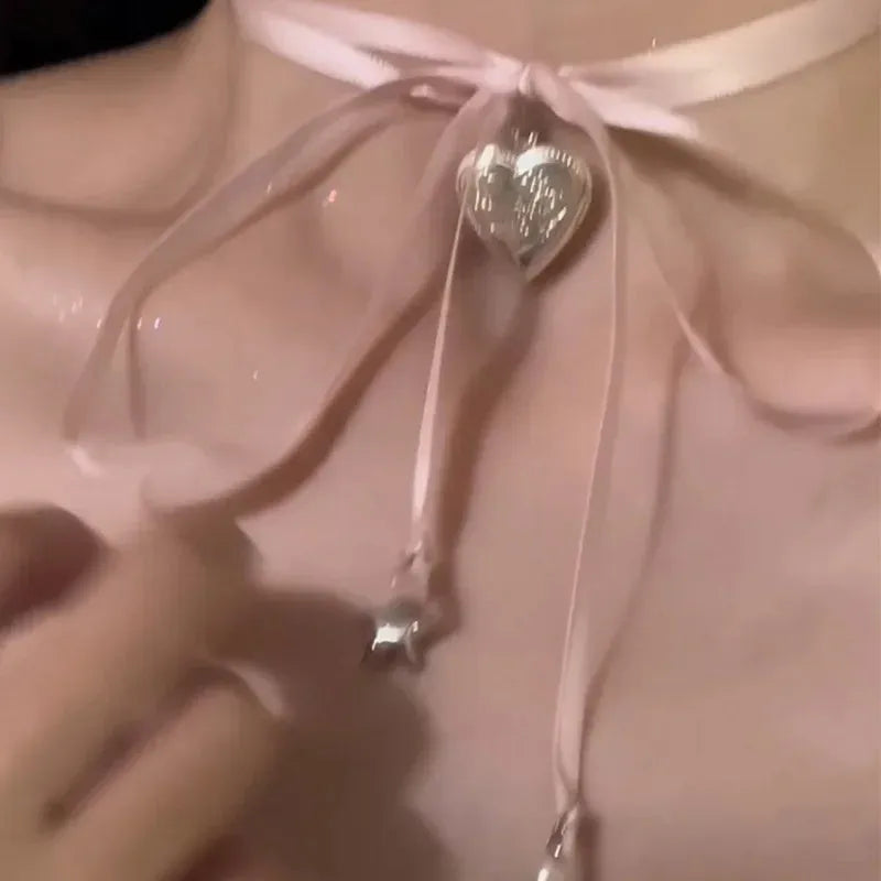 Women's alloy love pendant necklace with ribbon detail on a clavicle chain, electroplated finish.