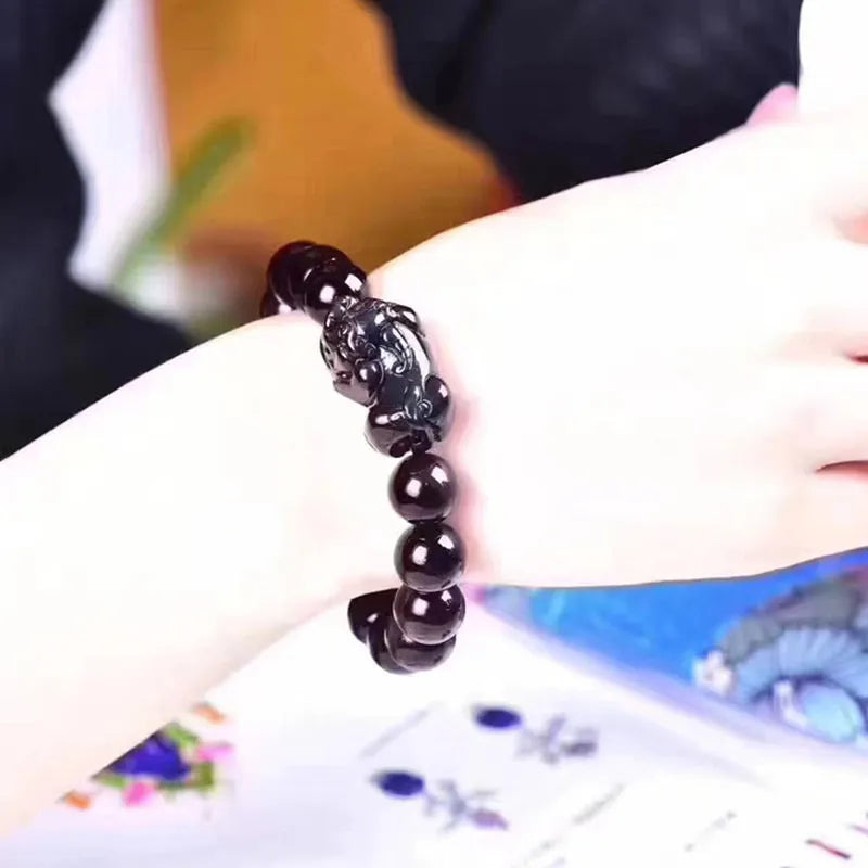 Natural ice colour eye obsidian crystal bracelet on a wrist, showing bead detail.