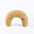 Blue U-shaped cat sleeping mat with moon design next to a yellow question mark shaped pet pillow.