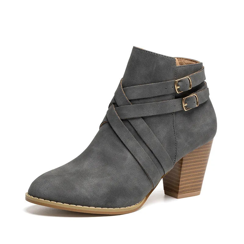 Women's black short boot with 7cm heel, side zipper, belt buckle, and rubber sole