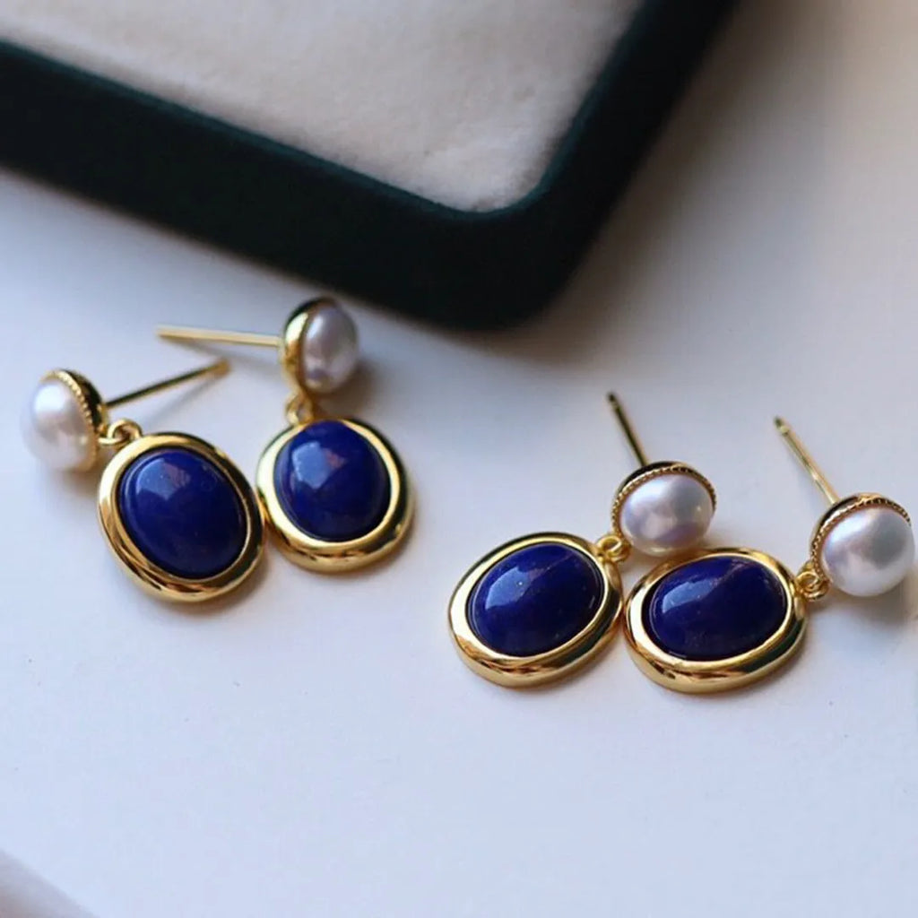 A pair of simple silver earrings with blue lapis lazuli pearls and auspicious patterns.