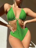 Women's black bikini swimsuit with gold chain detail on a model.