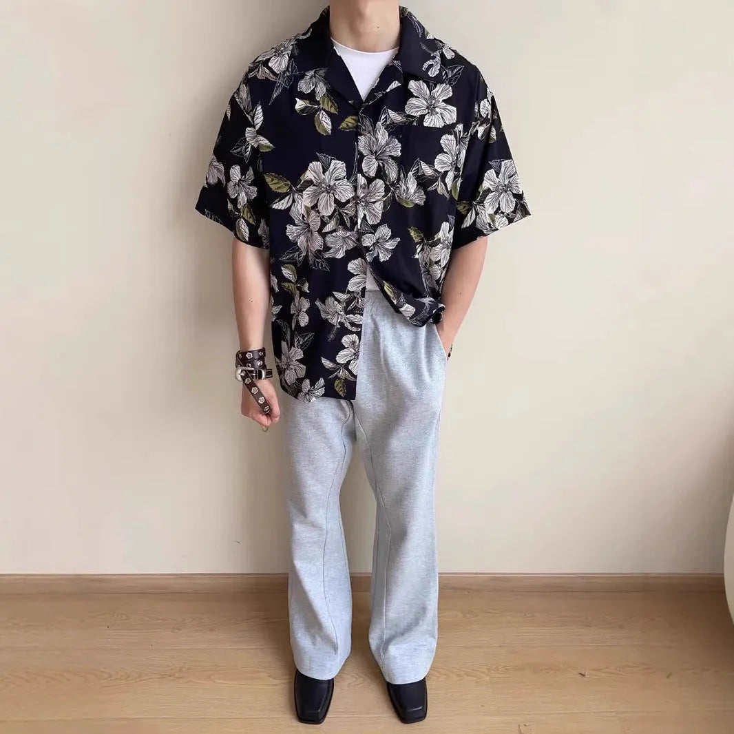 Black men's ice silk shirt with floral print, vintage Cuban collar, and short sleeves on a hanger.