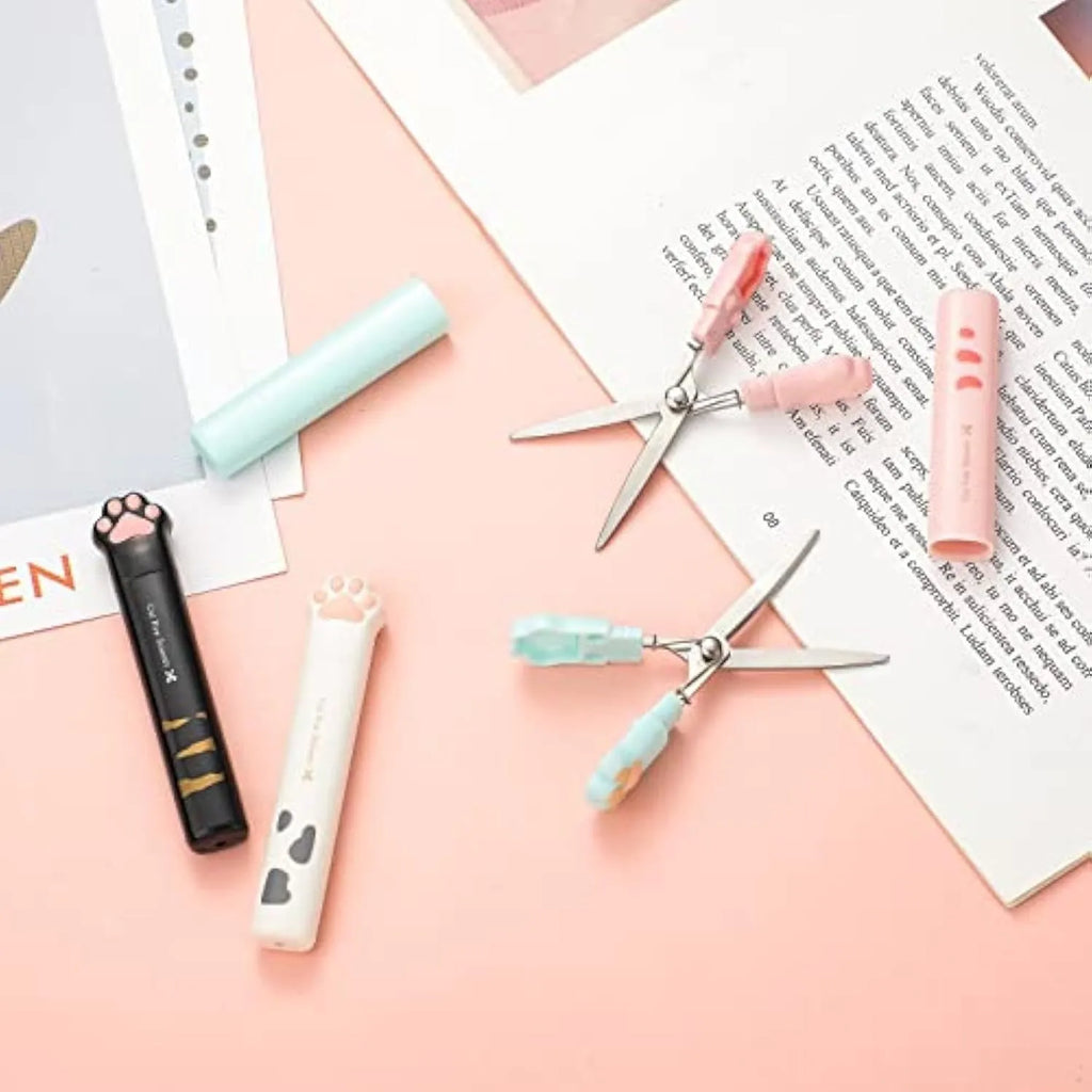 Mini folding craft scissors with cat paw handles in four colours: black, blue, pink, and white.