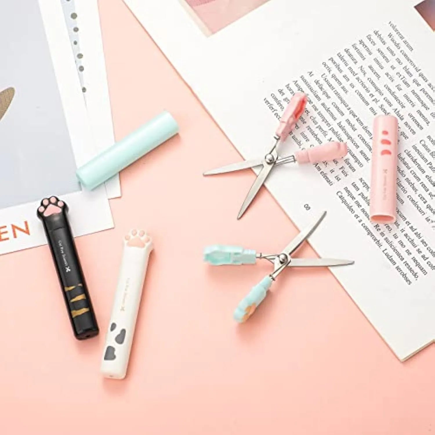 Mini folding craft scissors with cat paw handles in four colours: black, blue, pink, and white.