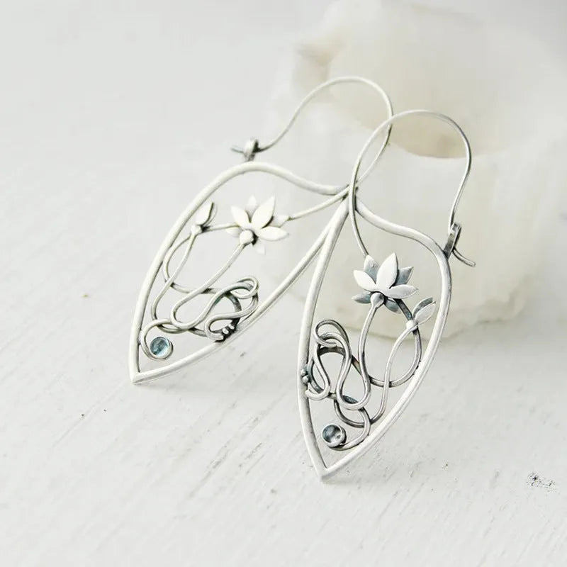 Silver lotus flower earrings with geometric shapes and rhinestone details