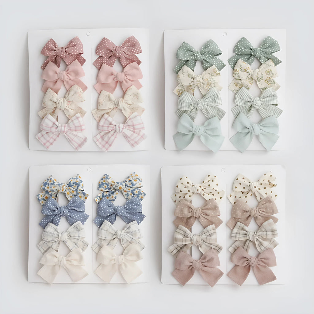 Set of eight fabric hairclips with dovetail bows in a chosen colour like beige grid dots or pink.