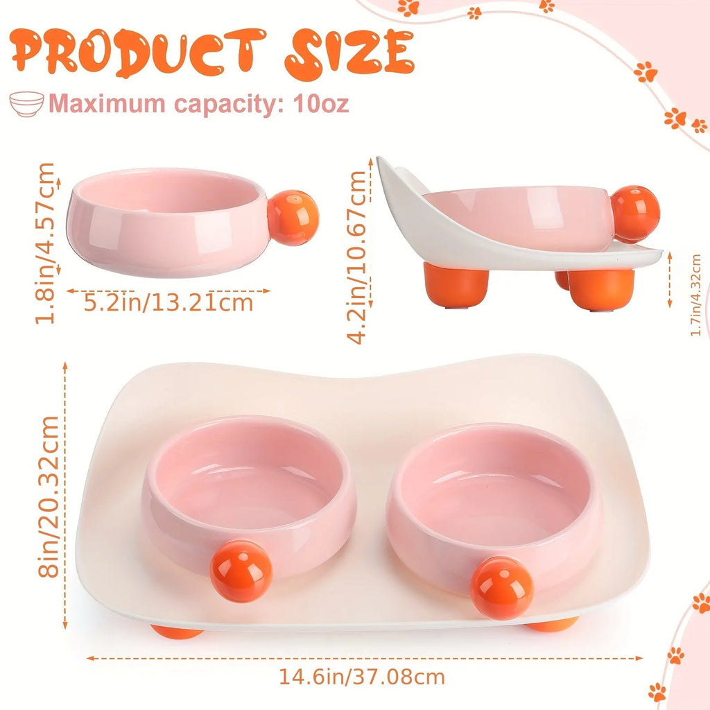 A pink ceramic raised pet bowl with two compartments and a non-slip black rubber base.