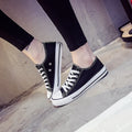 Women's solid colour canvas slip-on shoes in black, white, and red variations on a plain background.