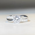 Geometric silver ring with 1 karat moissanite stone in four-claw setting and twisted arm winding band