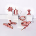 Classic velvet dog harness and lead set in red fleece with attached bow tie and waste bag holder.