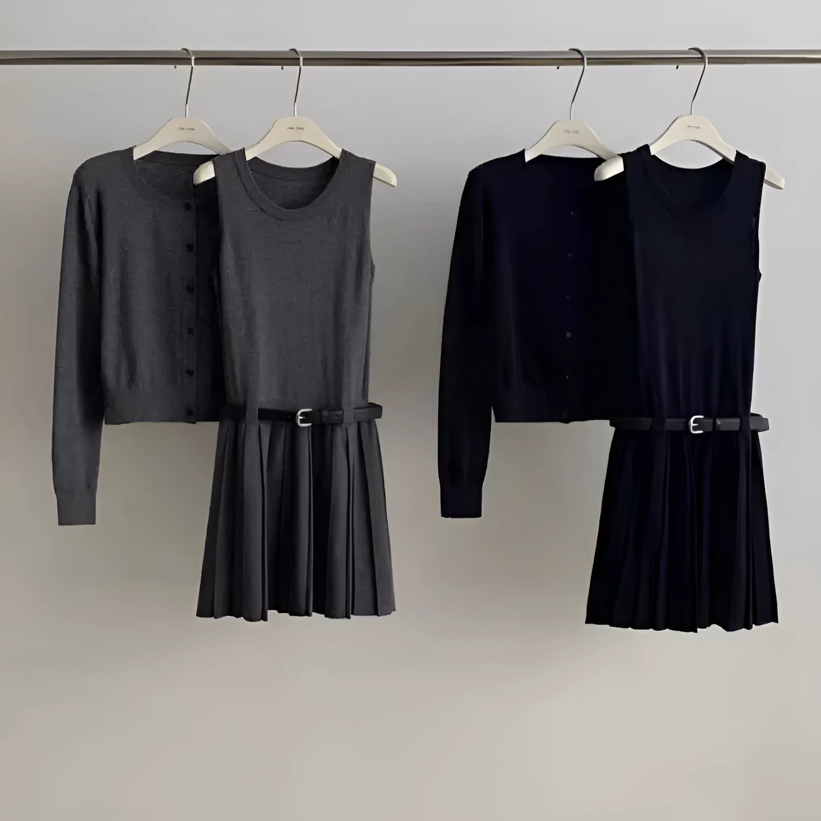 Women's black knitted polyester vest skirt and long sleeve cardigan two-piece set with a belt.