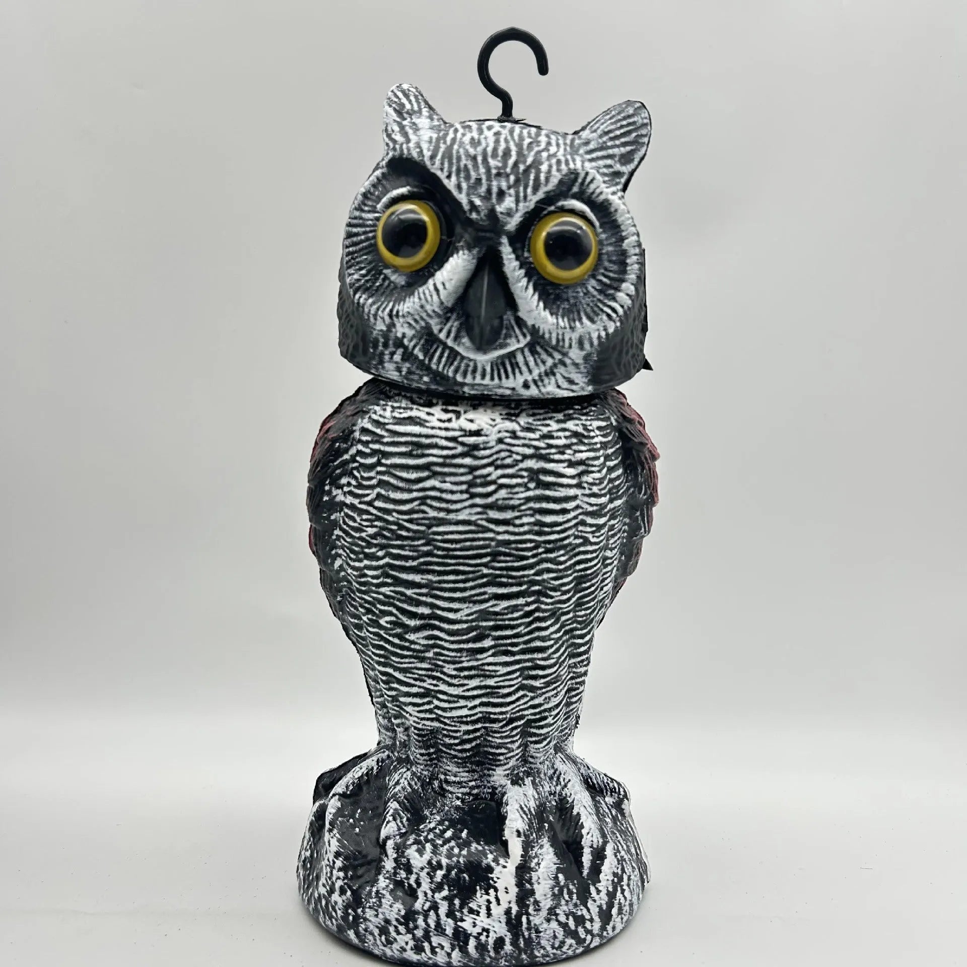 Artificial owl bait ornament with shaking head for garden bird deterrent in outdoor setting