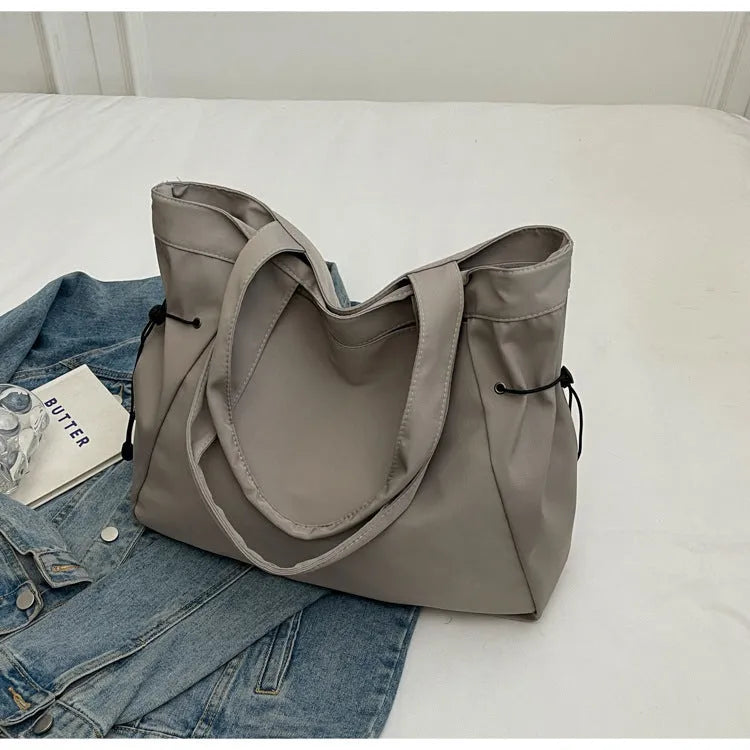 Soft Oxford cloth commuter tote bag in a street style, shown in a folded position.