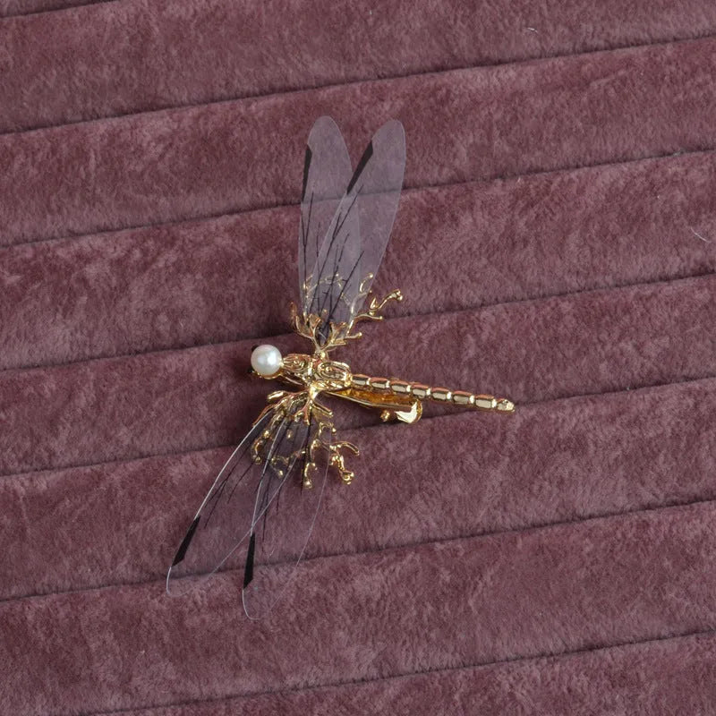 Golden alloy dragonfly-shaped side clip headdress for women on a white background.