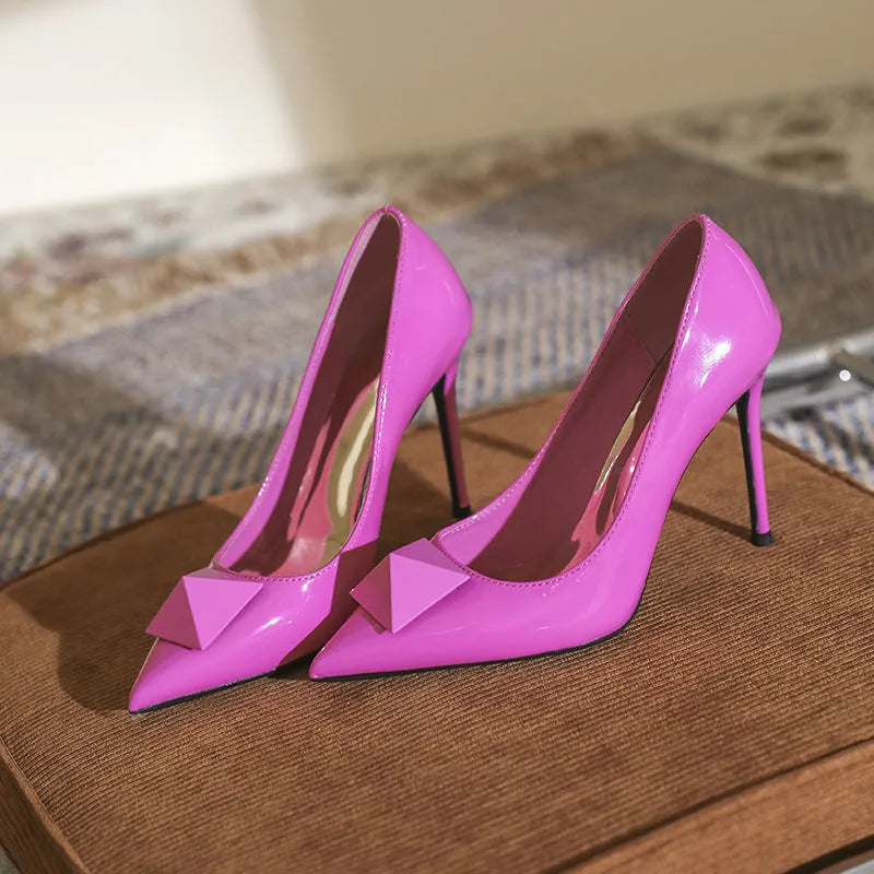 Pink patent leather women's stiletto heels with pointed toe and ankle buckle.