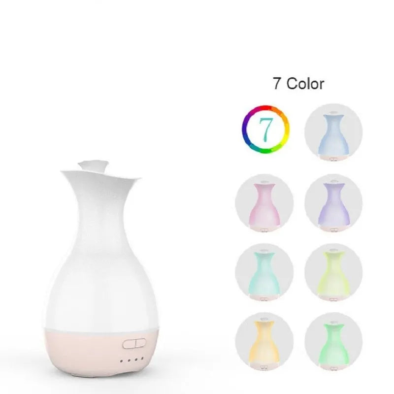 White ultrasonic aromatherapy diffuser and humidifier with colourful LED light misting on a wooden table.