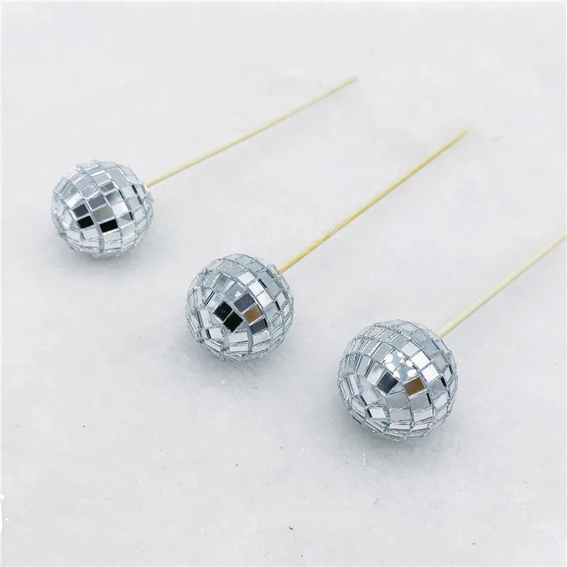 Glass disco ball cake decoration on a wooden stick, shown in different sizes.