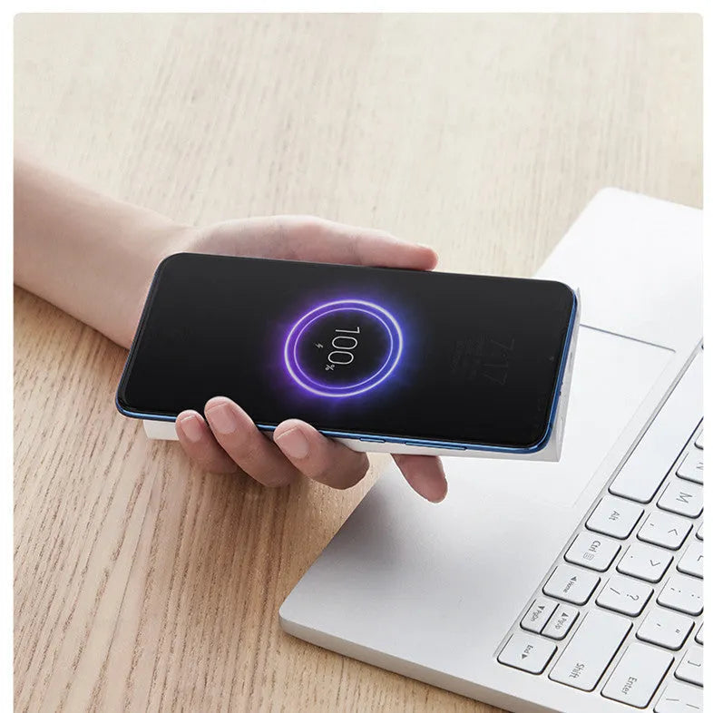 White 10000mAh power bank with USB port and wireless charging surface