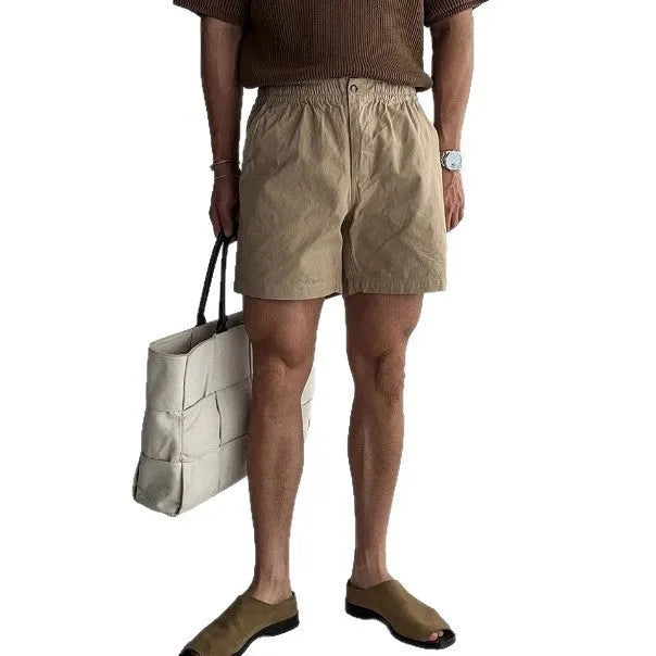 Man's loose-fit cotton sports shorts in khaki colour on a white background.