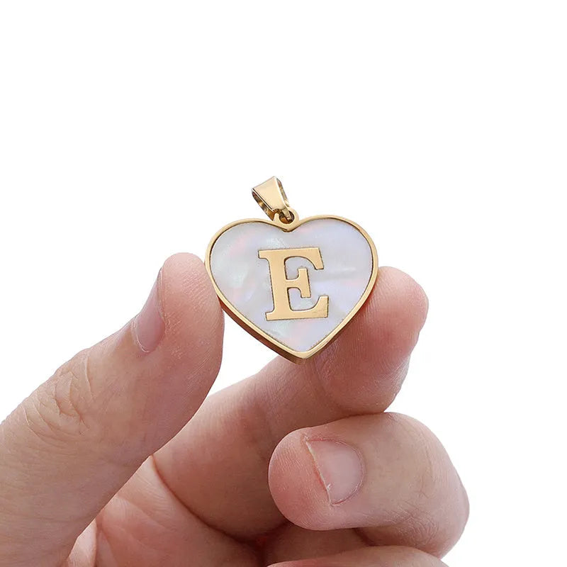 Gold plated heart pendant necklace with white shell centre on a stainless steel chain.