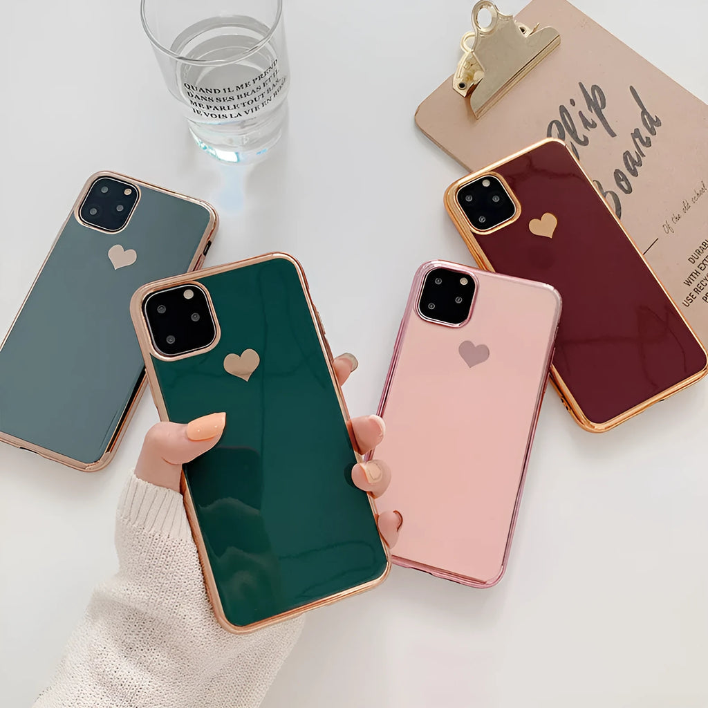 TPU iPhone case with solid colour and a raised metallic love heart design on the back.