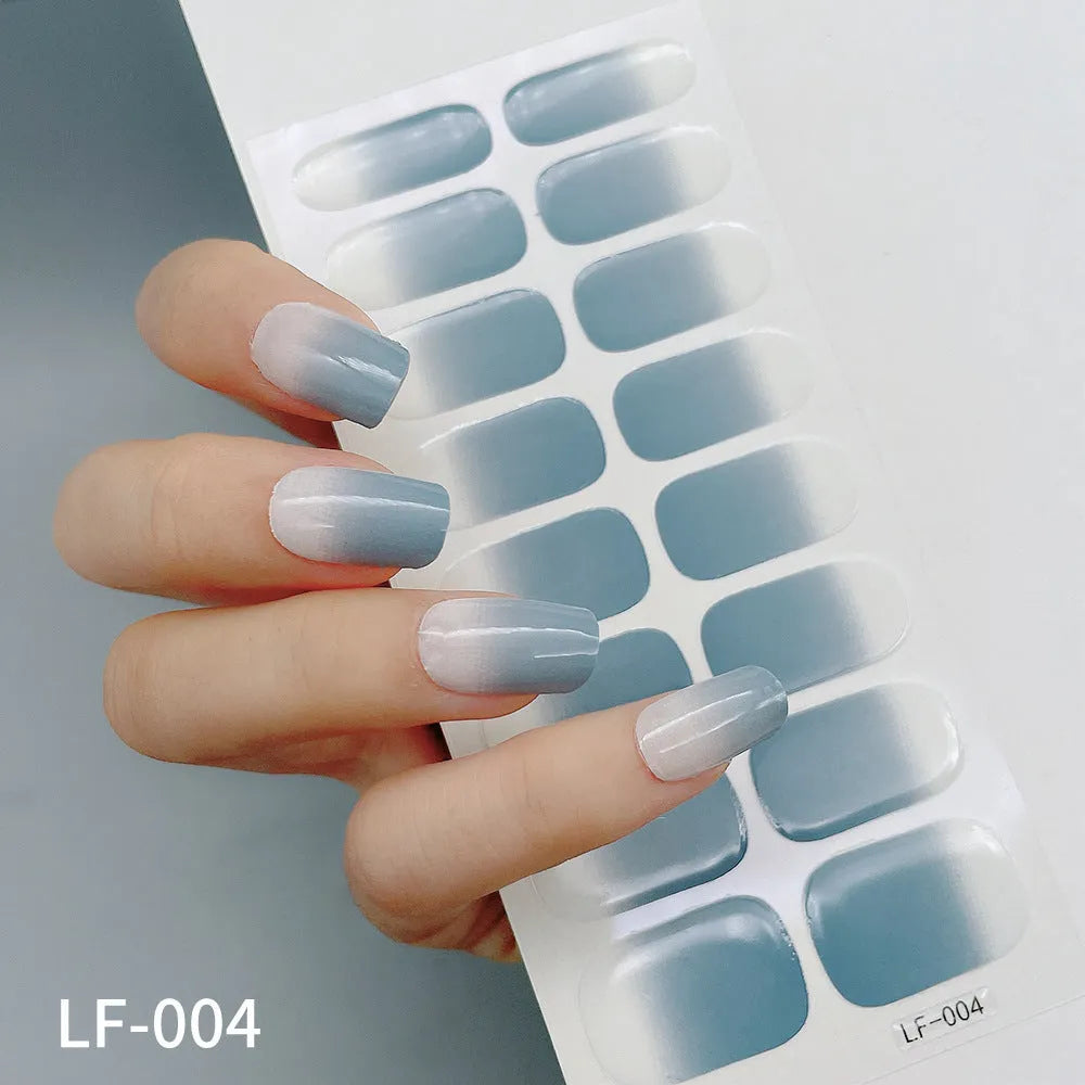 Set of 16 solid colour nail art stickers showing floral, geometric, and pattern designs for manicure application