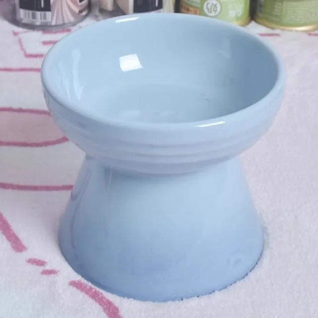Black ceramic pet bowl with a chin-high foot and raised neck protector on a white background.