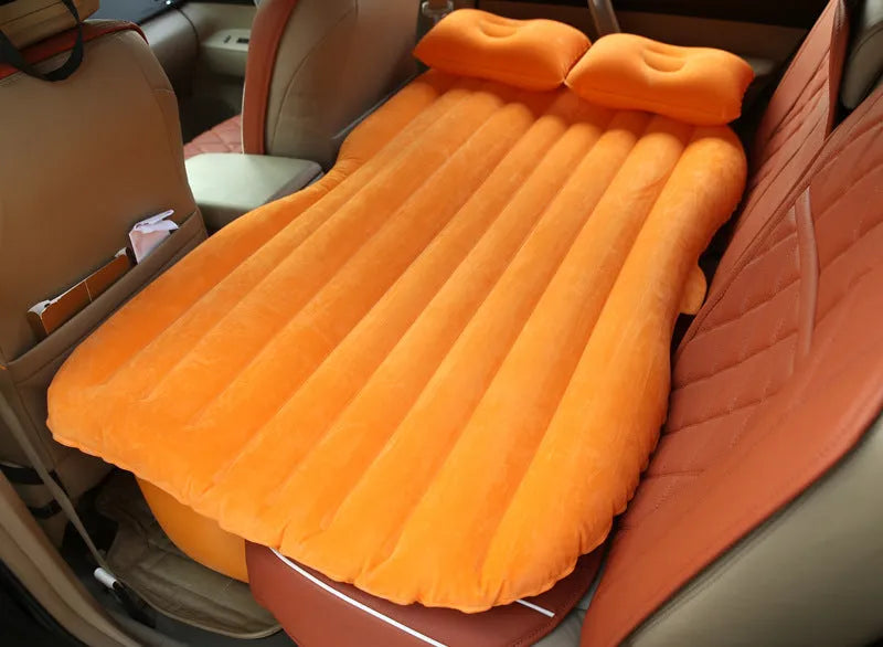 Black inflatable car bed with flocking surface and two pillows, shown folded next to a storage bag.