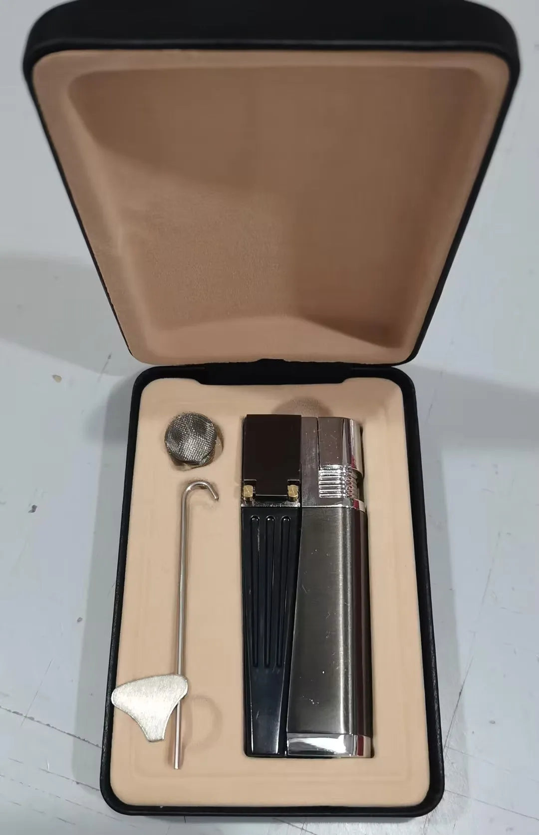 Silver and black foldable metal pipe lighter with stash compartment closed.