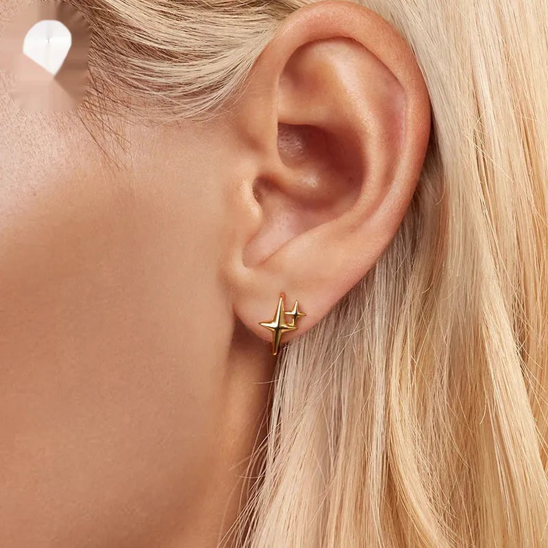Sterling silver minimalist star design clip-on earrings with XINGX detail and oxidation finish.