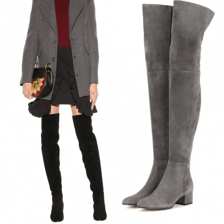 Grey suede women's over the knee flat boots with a pointed toe and low block heel on a neutral background.