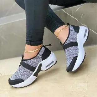 Women's flat sneakers in light grey with mesh upper, round toe, and rubber sole.